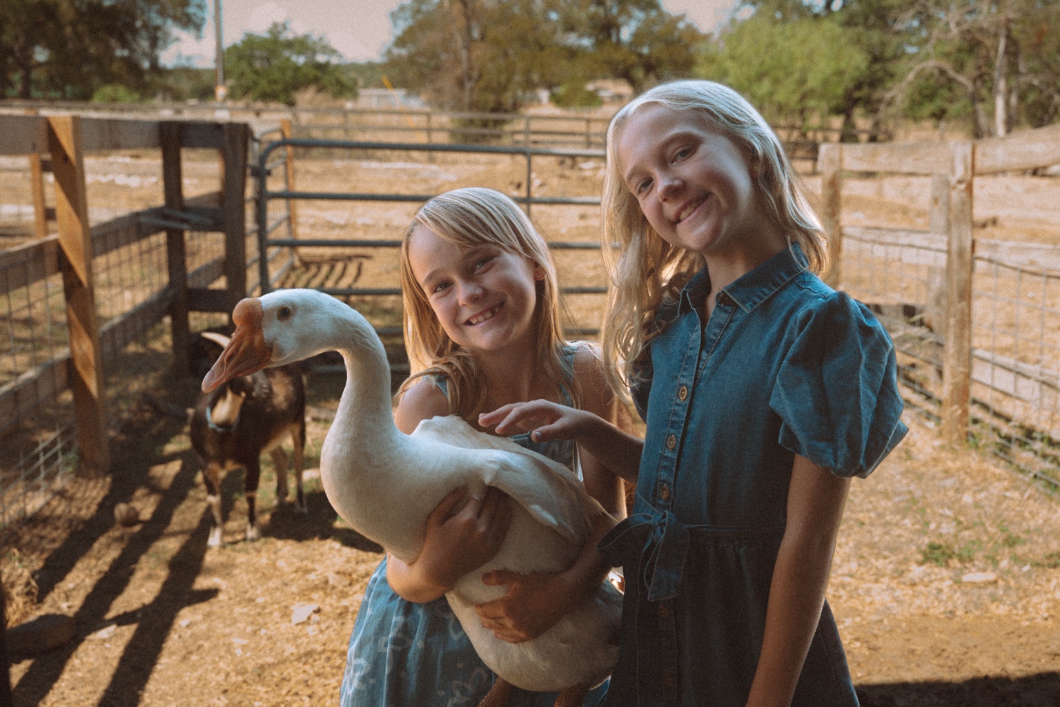 Two girls smiling with Mother Goose at Feral Farmstead